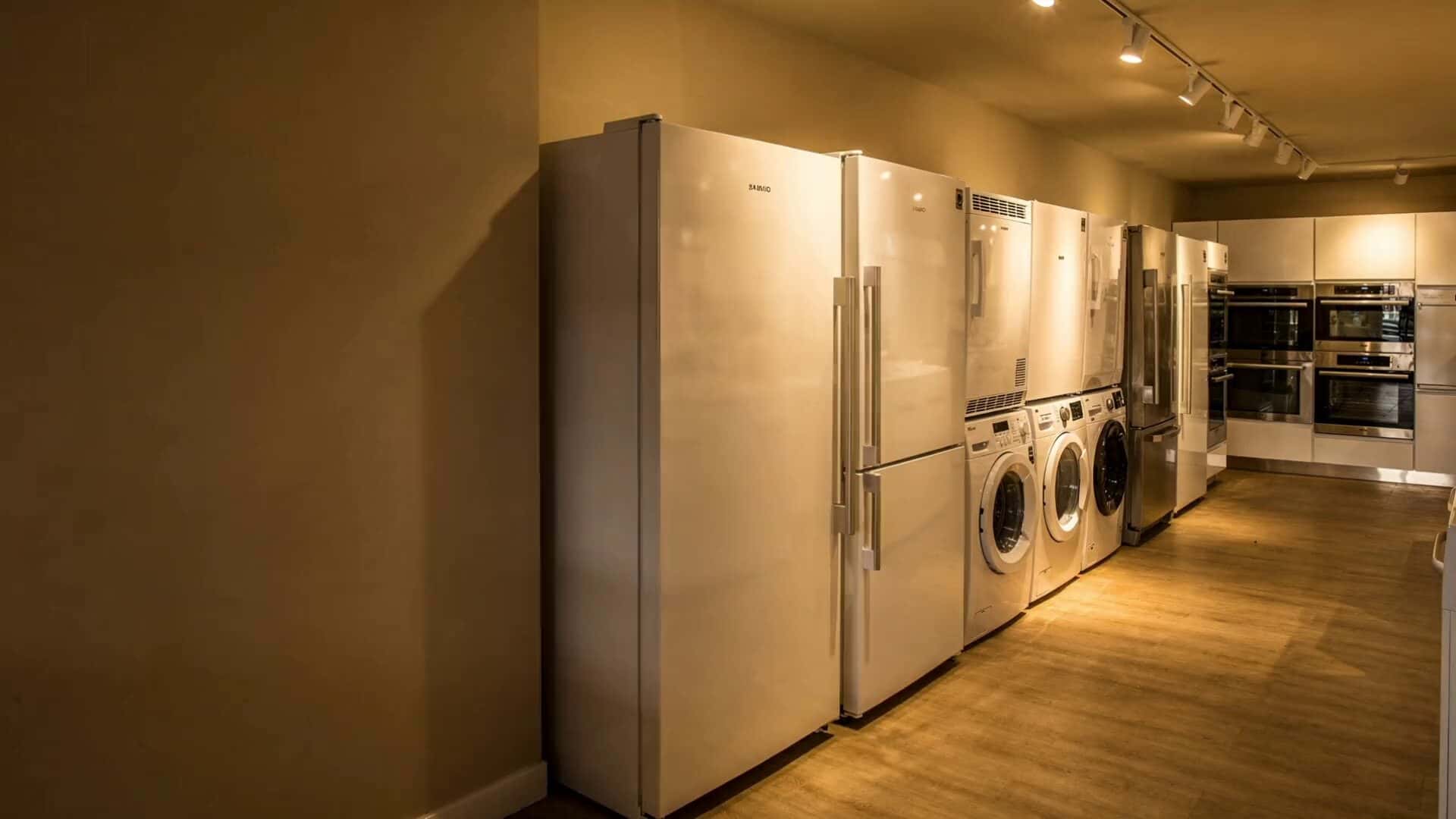 Warm beleuchteter Ausstellungsraum mit Kühlschränken, Waschmaschinen und Backöfen